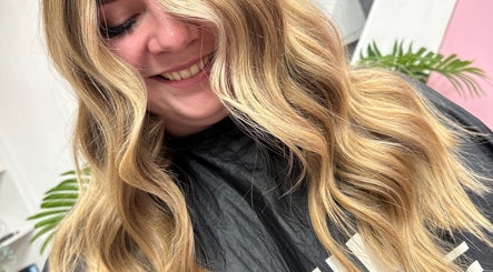 Woman with flowing golden waves at Hannah Elizabeth Hair, Newcastle-under-Lyme, England, GB.