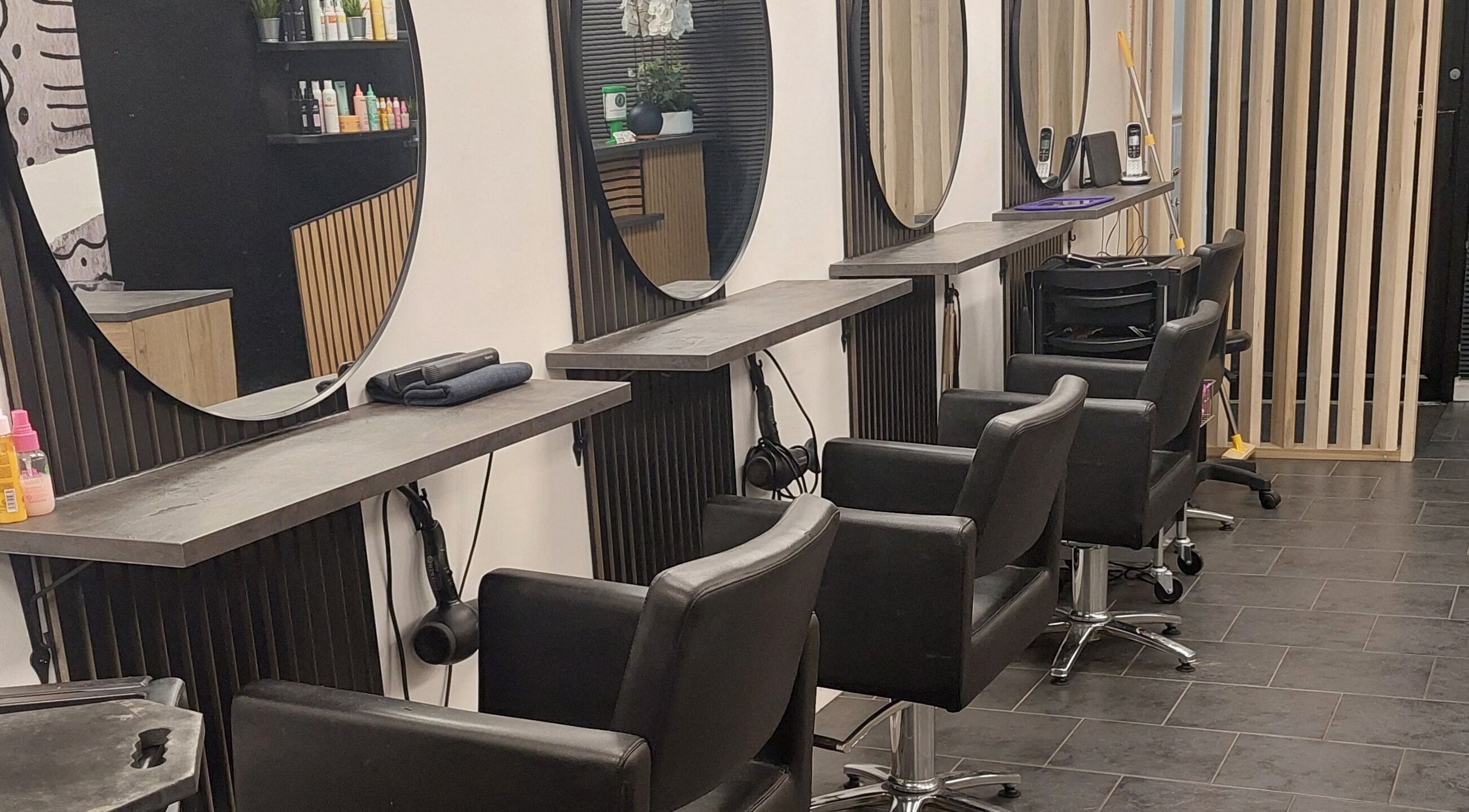 Modern hair styling area at Salon19 Coleraine, Coleraine, Northern Ireland, GB with sleek chairs and mirrors.