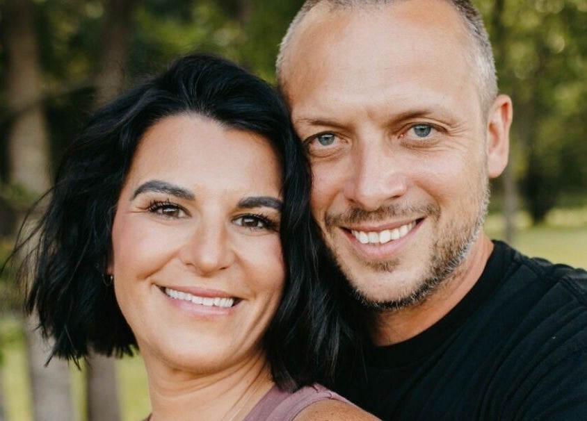 Smiling couple at Blair Derry Salon, Waverly, Minnesota, US, in a lush outdoor setting.