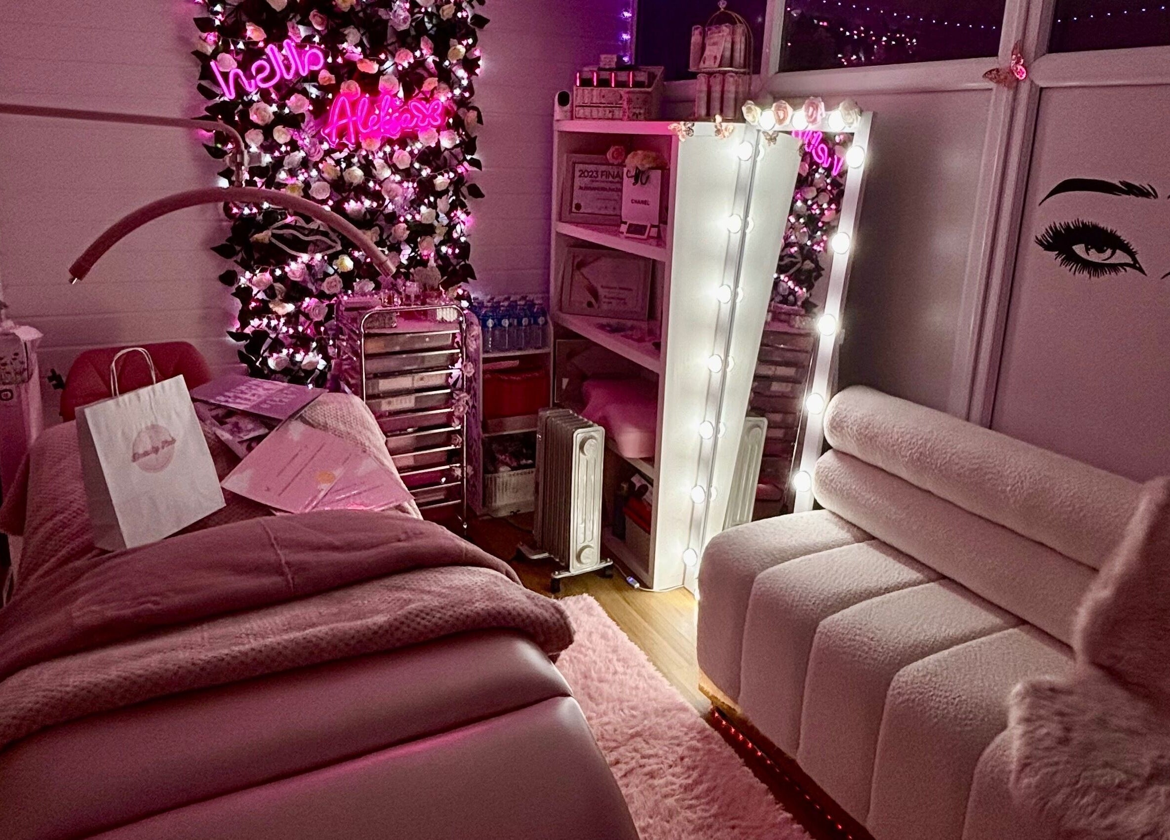 Cozy treatment room at Aleksa Beauty Lab in Leeds, England, GB, with pink accents and floral decor.
