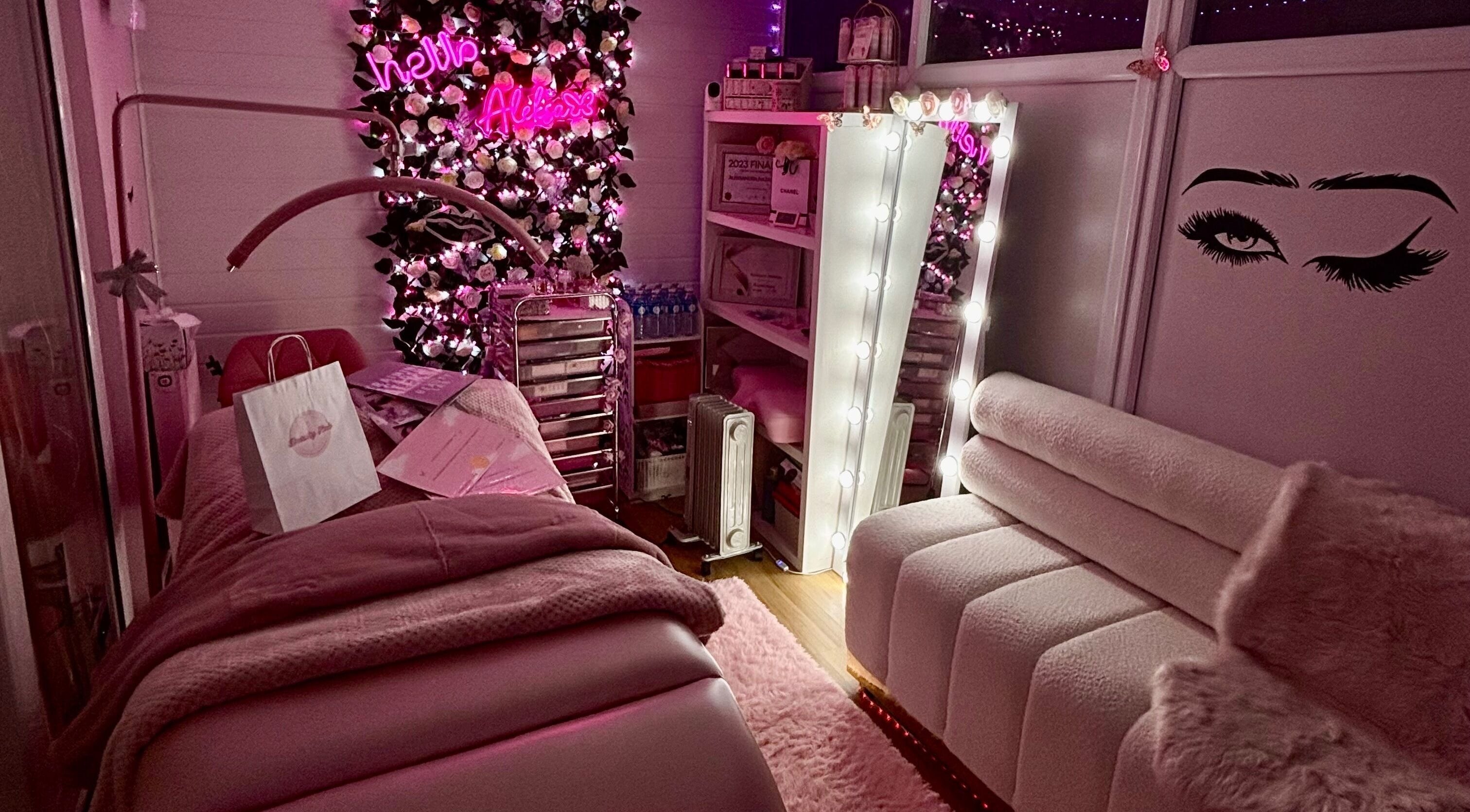 Cozy treatment room at Aleksa Beauty Lab in Leeds, England, GB, with pink accents and floral decor.