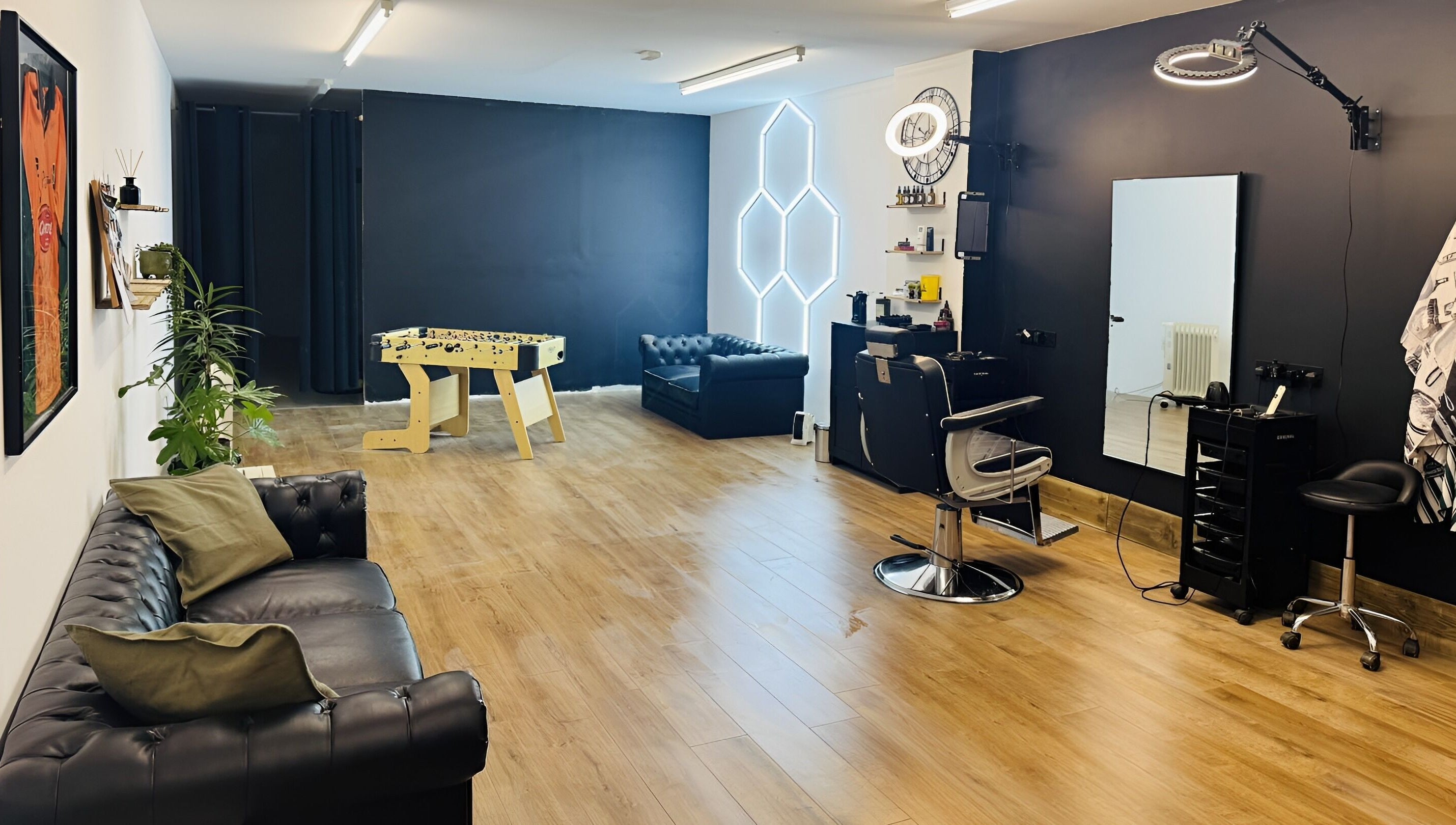 Modern interior of Chris Brown - The Barber in Plymouth, England, GB, featuring leather seating and styling stations.