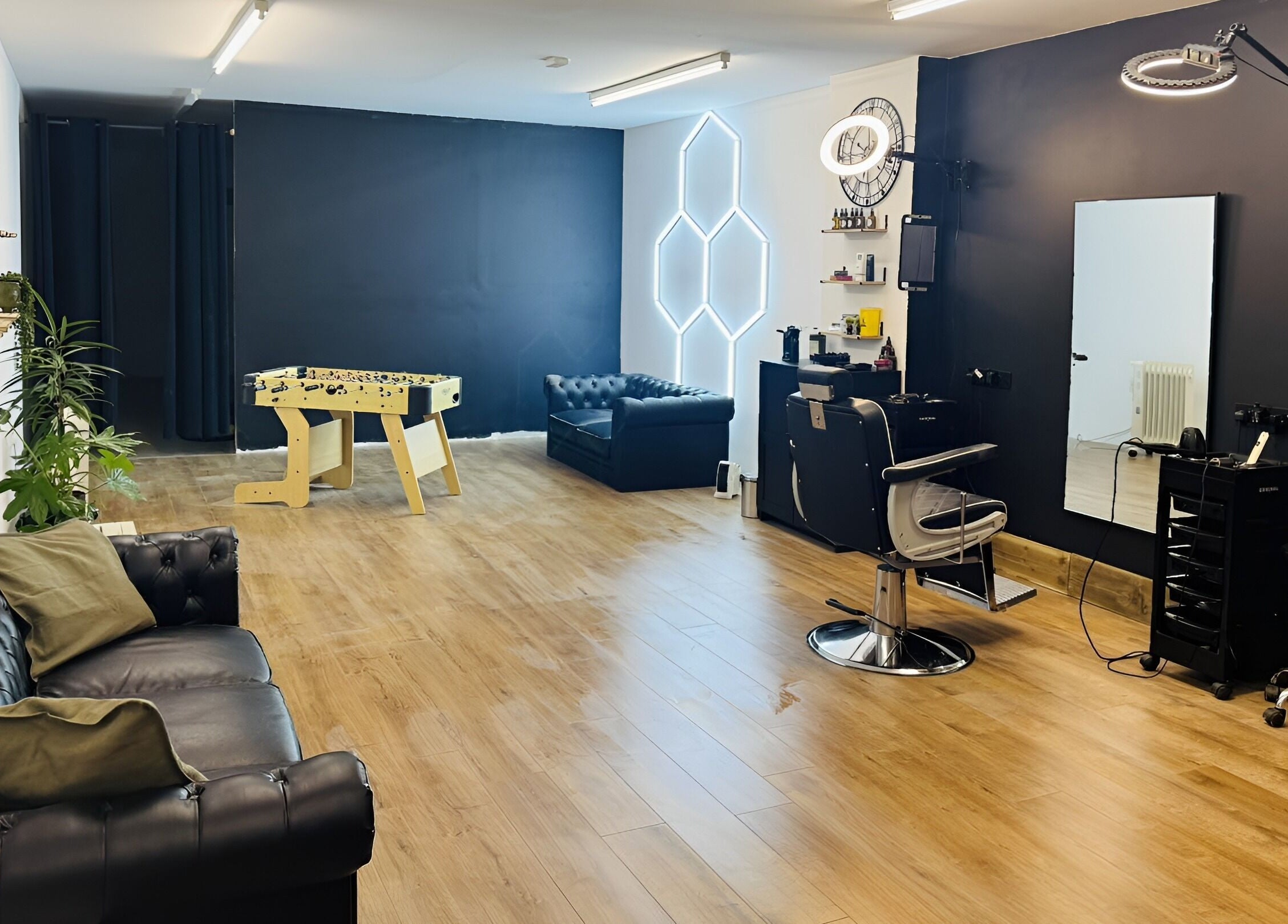 Modern interior of Chris Brown - The Barber in Plymouth, England, GB, featuring leather seating and styling stations.