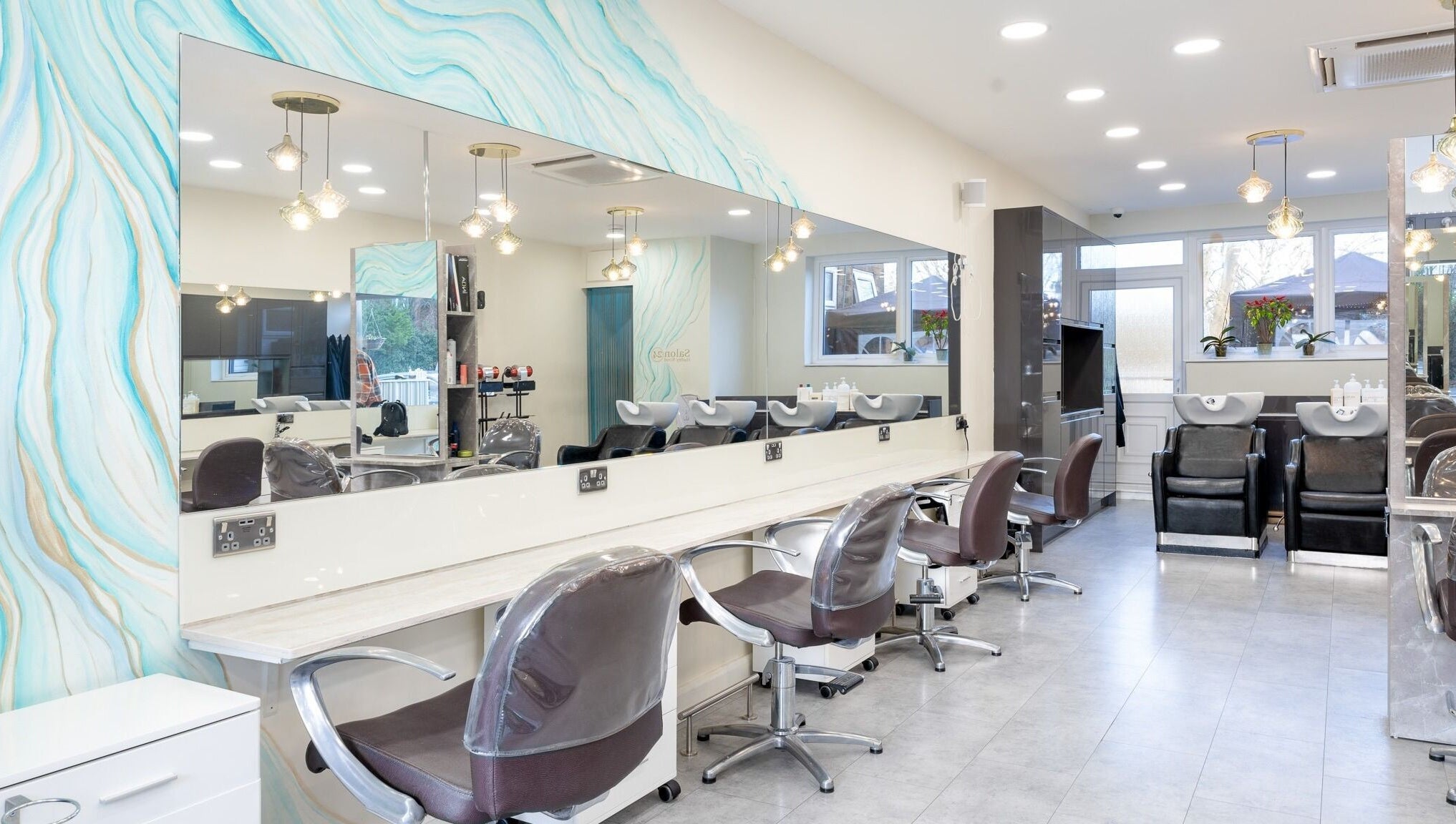 Modern interior of Salon 24 Hadley Wood in Barnet, England, GB with stylish chairs and wash stations.