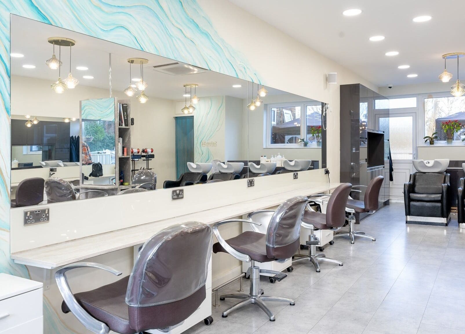 Modern interior of Salon 24 Hadley Wood in Barnet, England, GB with stylish chairs and wash stations.