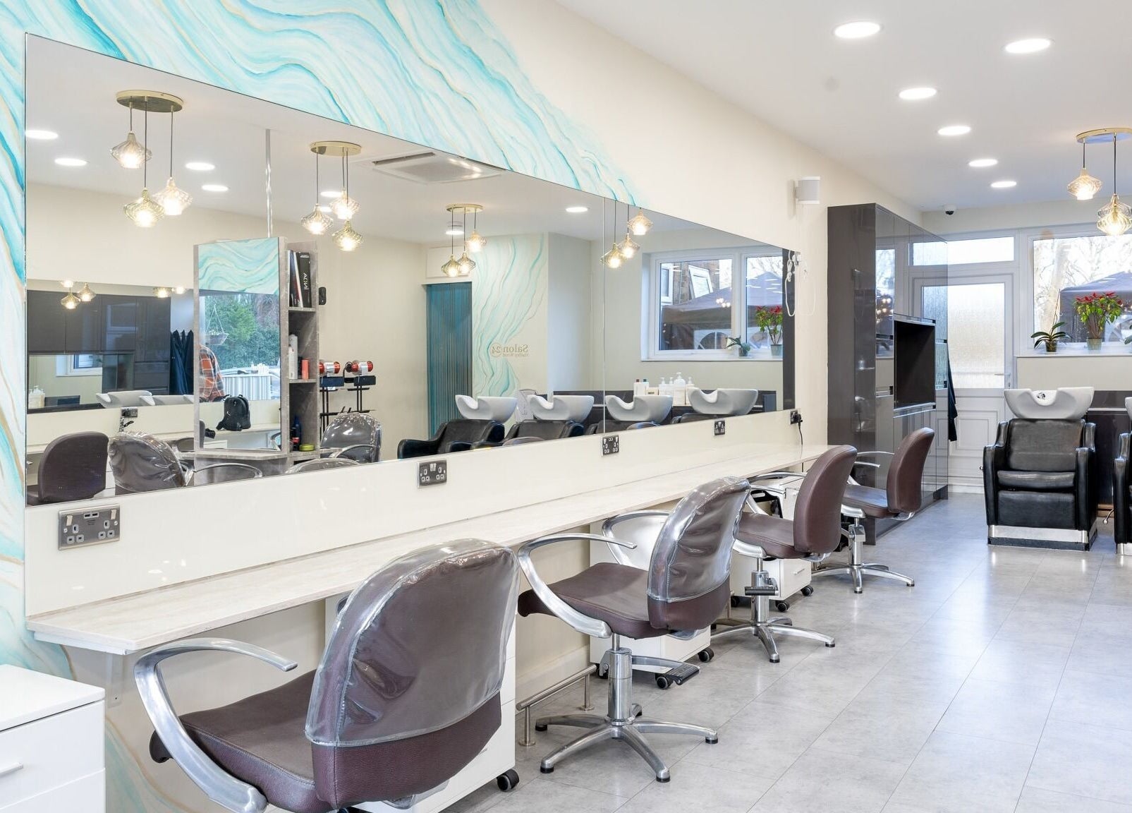 Modern interior of Salon 24 Hadley Wood in Barnet, England, GB with stylish chairs and wash stations.
