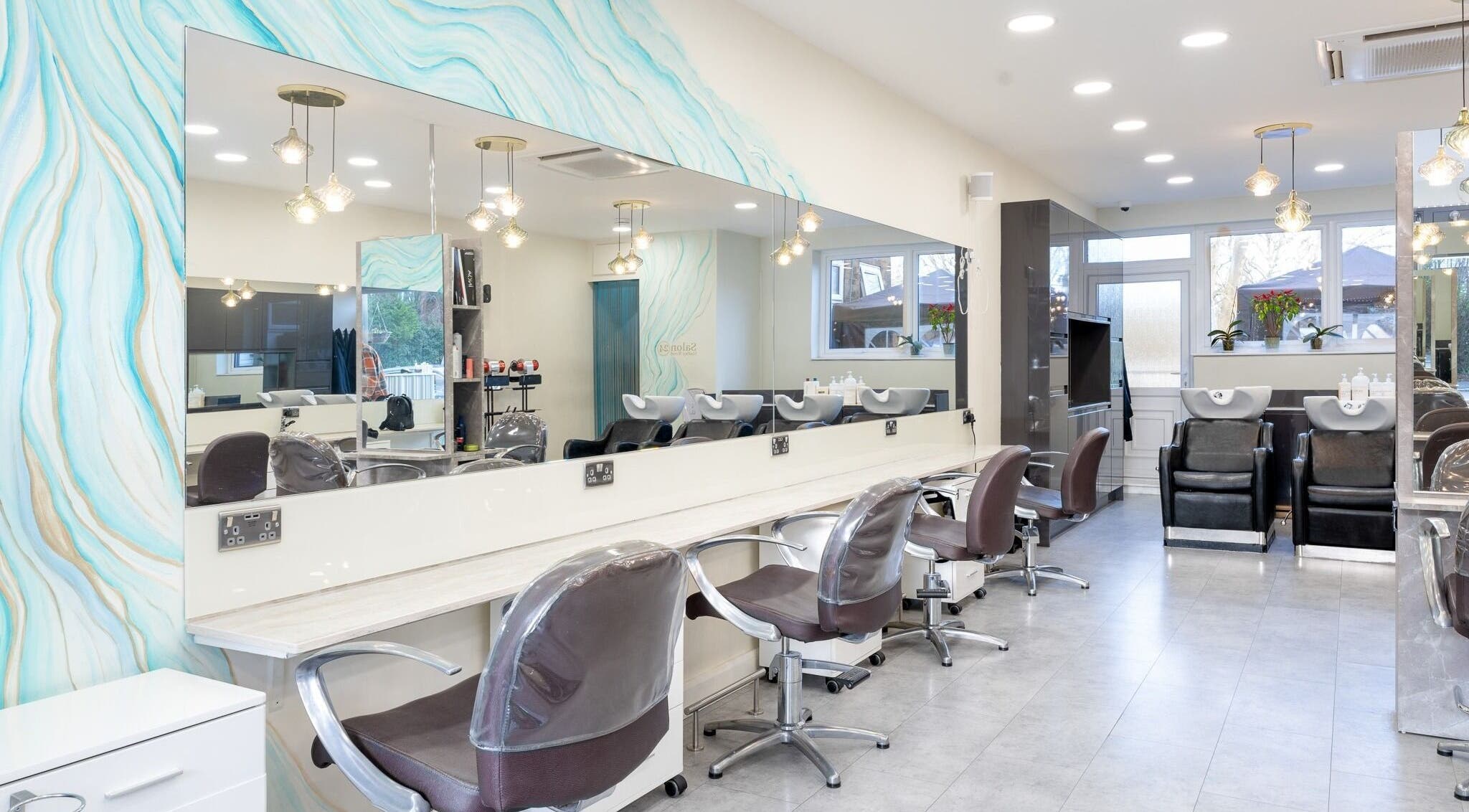 Modern interior of Salon 24 Hadley Wood in Barnet, England, GB with stylish chairs and wash stations.