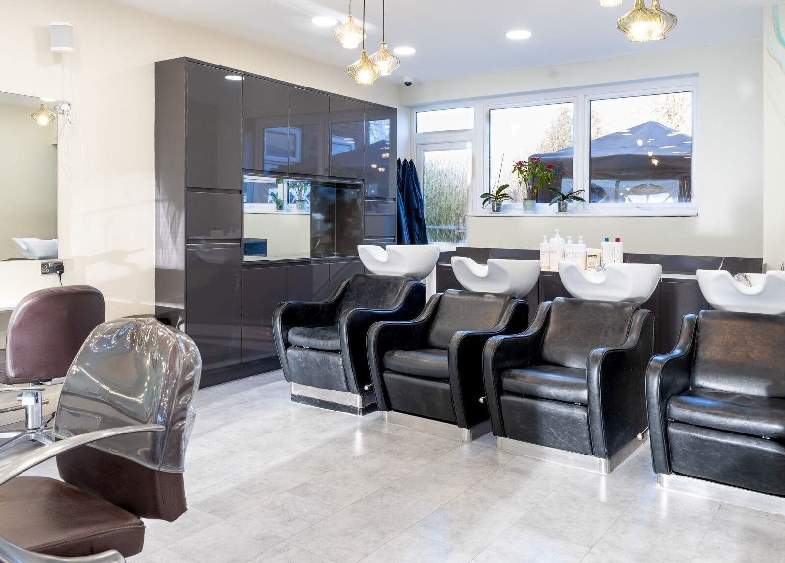 Modern salon interior at Salon 24 Hadley Wood, Barnet, England, GB featuring sleek washing stations.