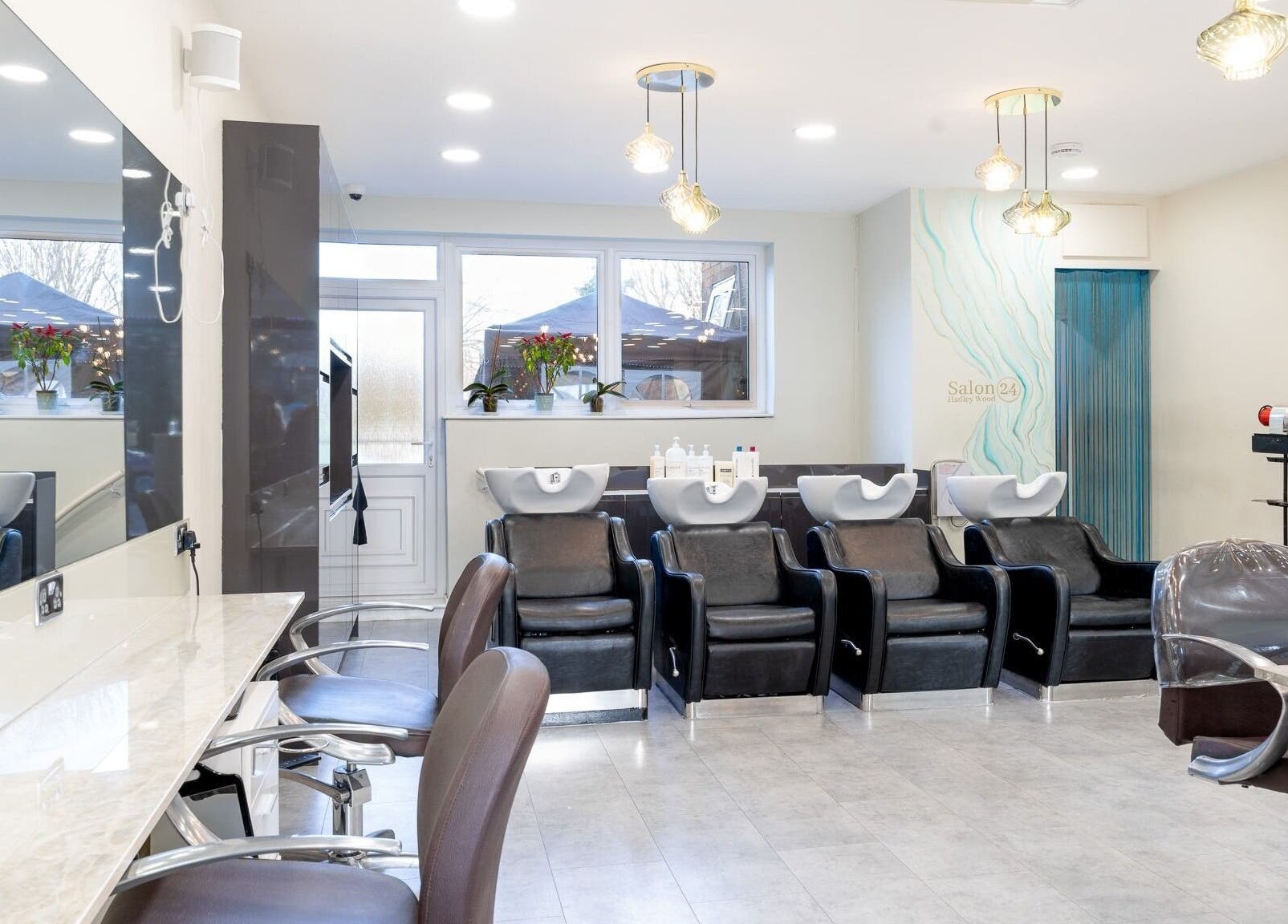 Modern interior of Salon 24 Hadley Wood, Barnet, England, GB with sleek salon chairs and wash stations.