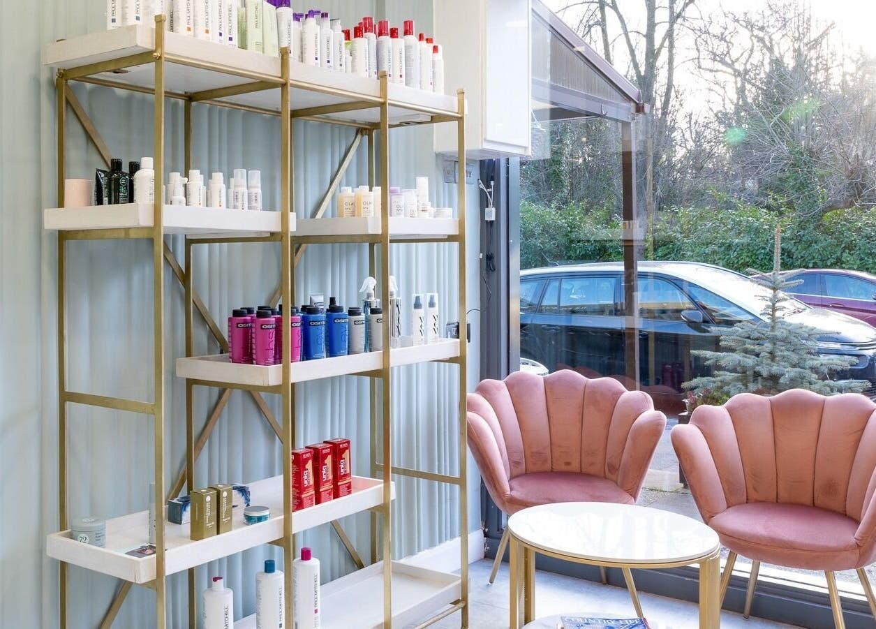 Salon 24 Hadley Wood's elegant lounge area in Barnet, England, GB with plush pink chairs and product display.