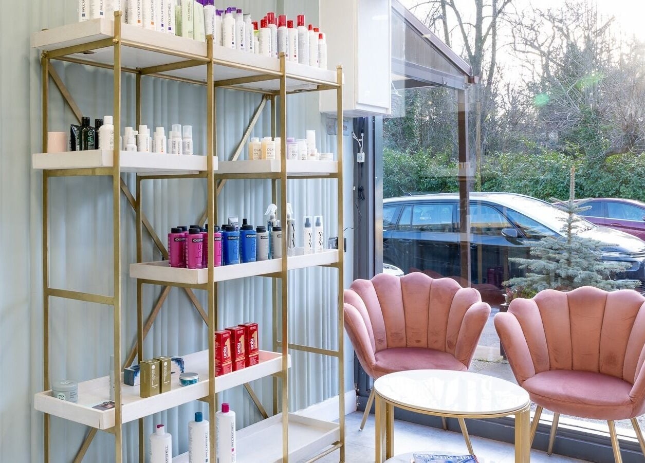 Salon 24 Hadley Wood's elegant lounge area in Barnet, England, GB with plush pink chairs and product display.