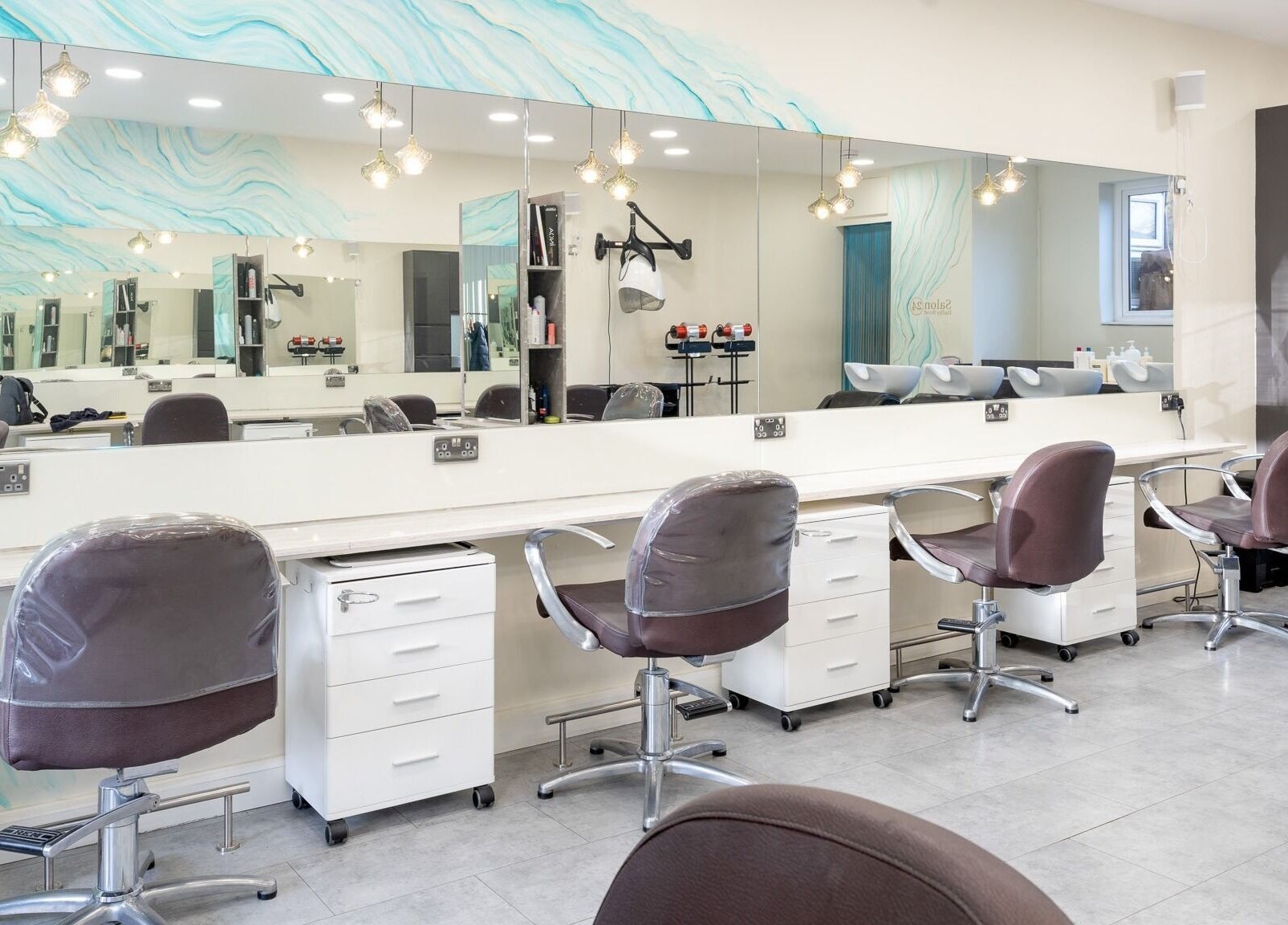 Elegant styling stations at Salon 24 Hadley Wood, Barnet, England, GB, featuring modern decor and plush chairs.