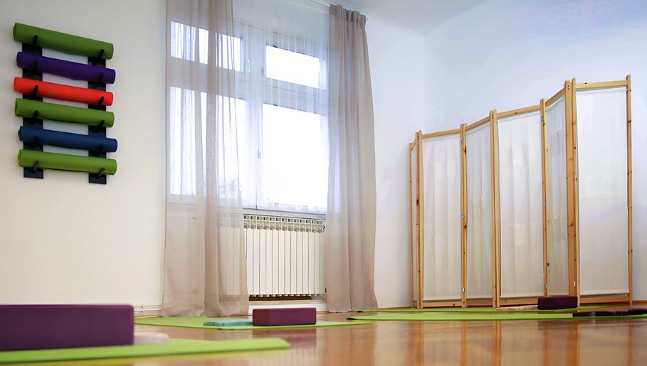 Svijetla yoga soba u Dodirom Do Zdravlja - Yoga and Bodywork, Zagreb, Grad Zagreb, HR s prostirkama i rekvizitima.