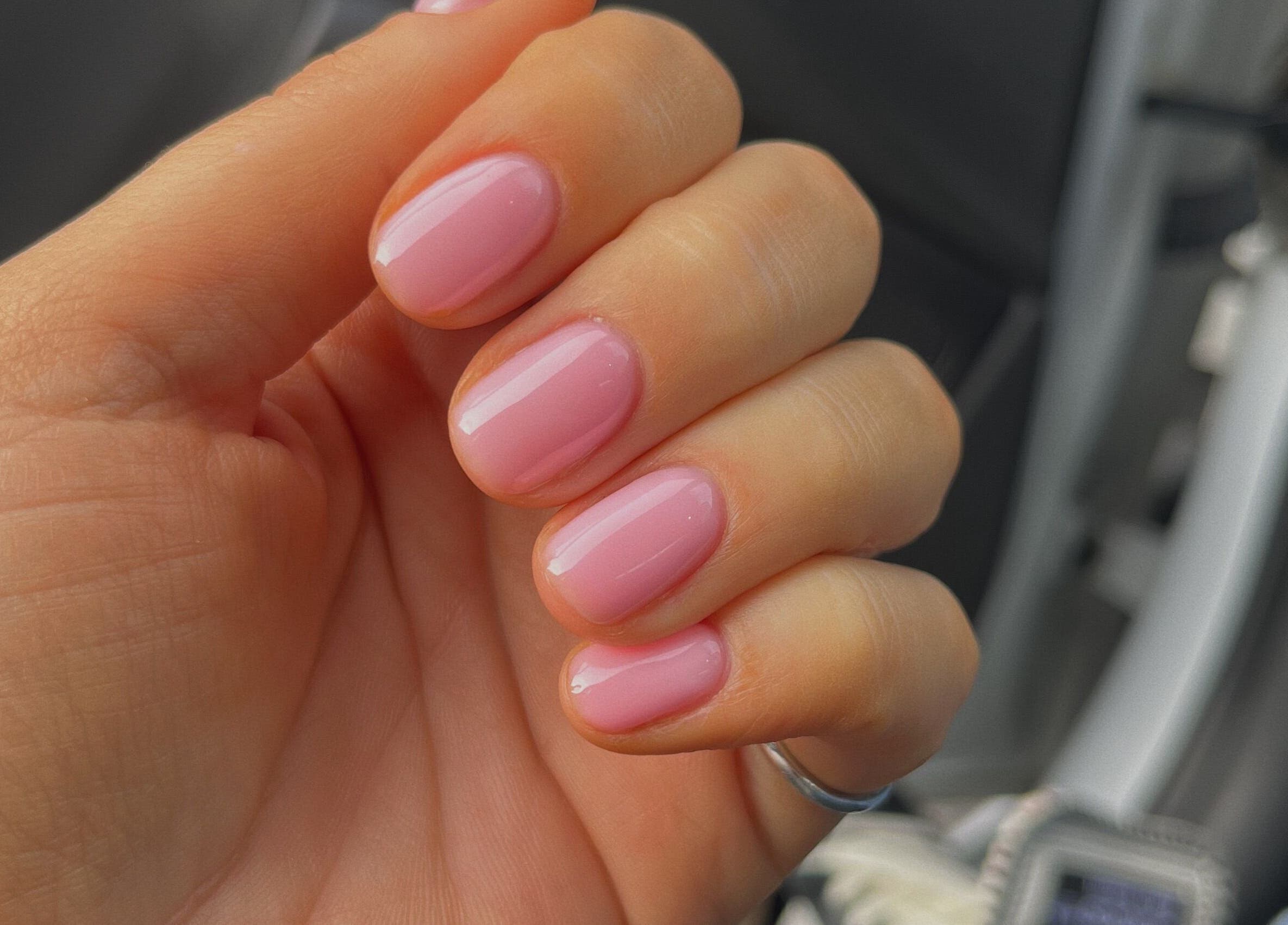 Glossy pink manicure at Port Studio, Stockport, England, GB. Hand with elegant light pink nails.