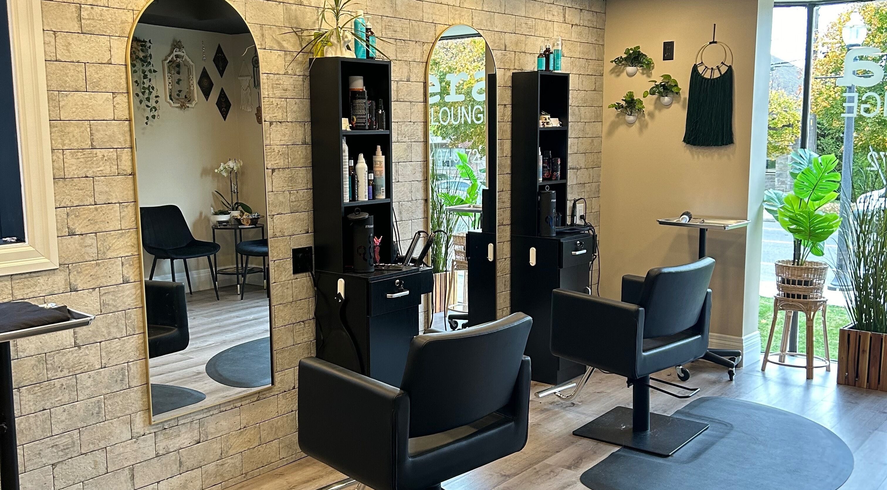 Elegant salon interior of Nera Hair Lounge in Hamilton, Ontario, CA with sleek styling stations and mirrors.