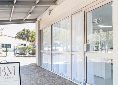Front entrance of SBM The Salon at Boronia Heights, Queensland, AU, showcasing glass doors and salon signage.