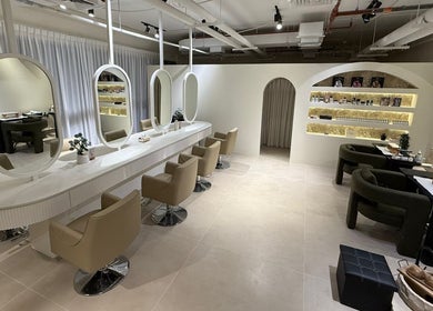 Stylish interior of Her Salon in Dubai, Dubai, AE with elegant chairs and mirrors in a calming ambiance.