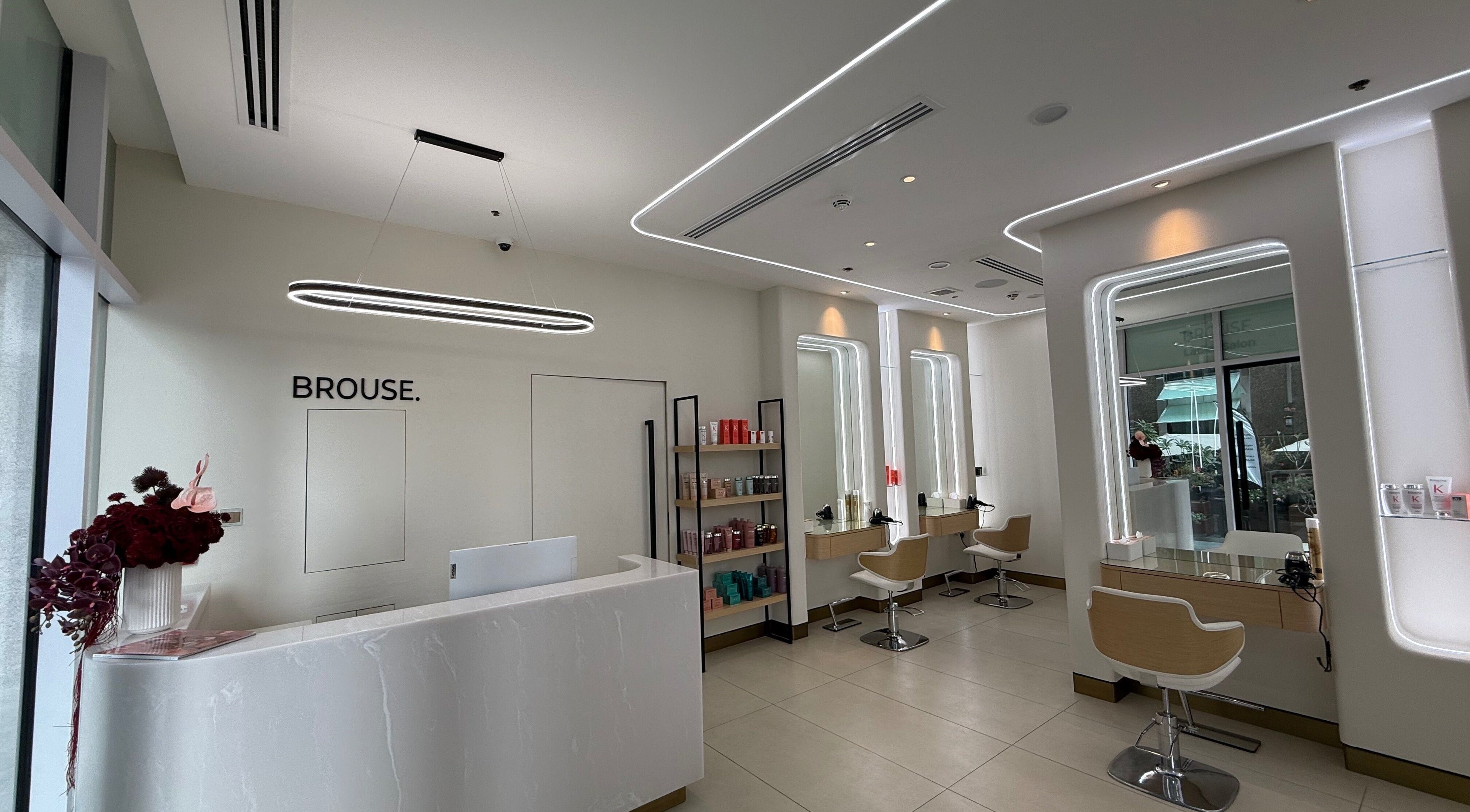 Chic interior of BROUSE. Brow, Hair & Beauty House in Dubai, Dubai, AE featuring modern salon stations.