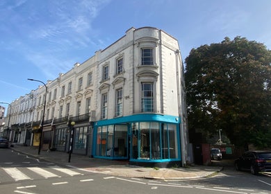 Street view of Blue Barbers in a classic building, London, England, GB, under a clear blue sky.