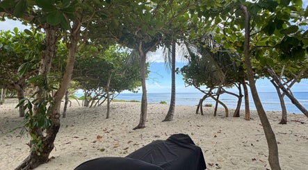Relaxing beach massage setup by Mobile Treatments in Saint Michael, Saint Michael, BB, under lush tropical trees.