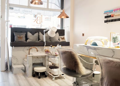 Interior of NOGTI Nails Fitzrovia, London, England, GB, showcasing chic seating and professional nail supplies.