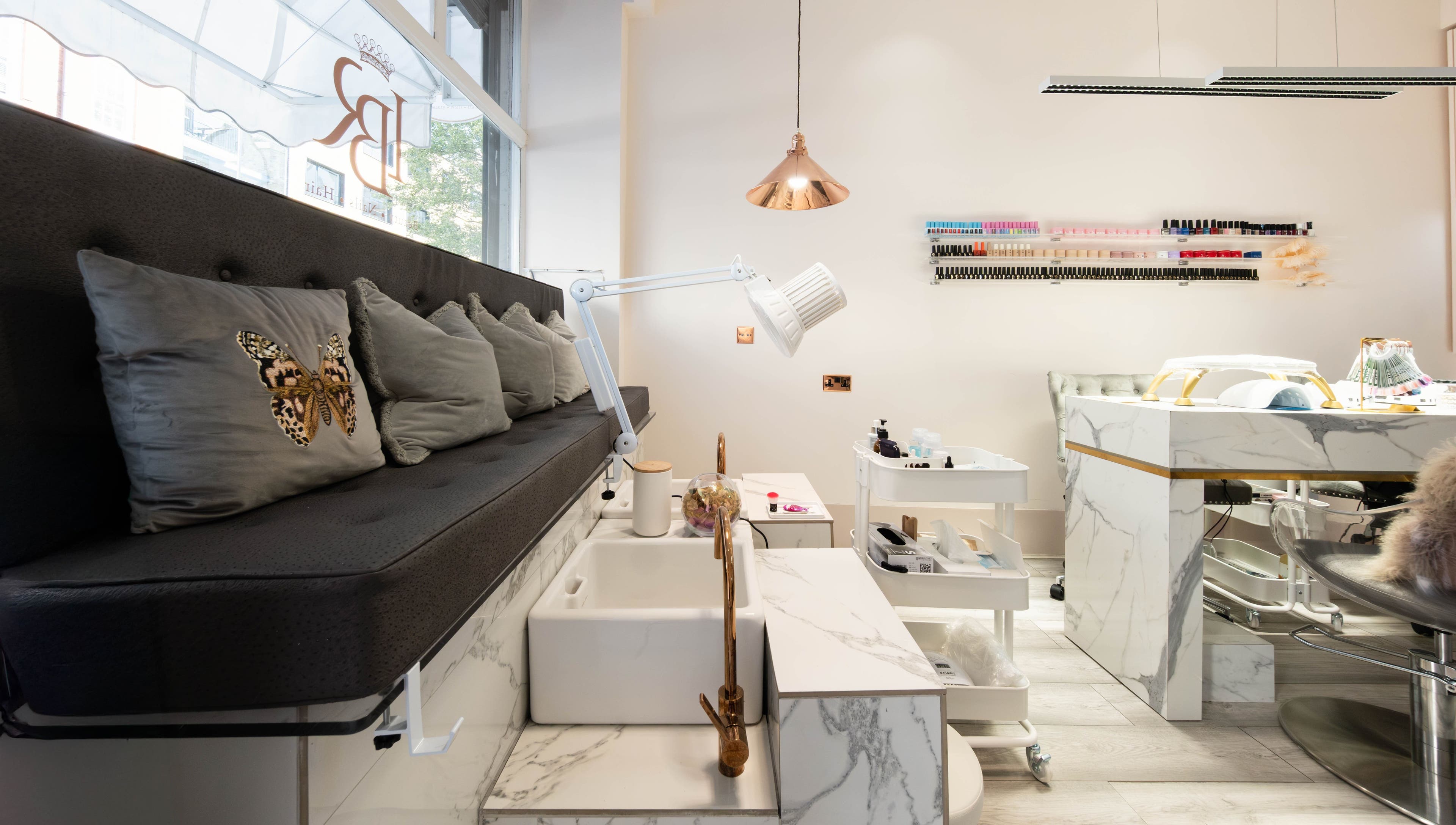 Elegant interior of NOGTI Nails Fitzrovia in London, England, GB with plush seating and manicure stations.