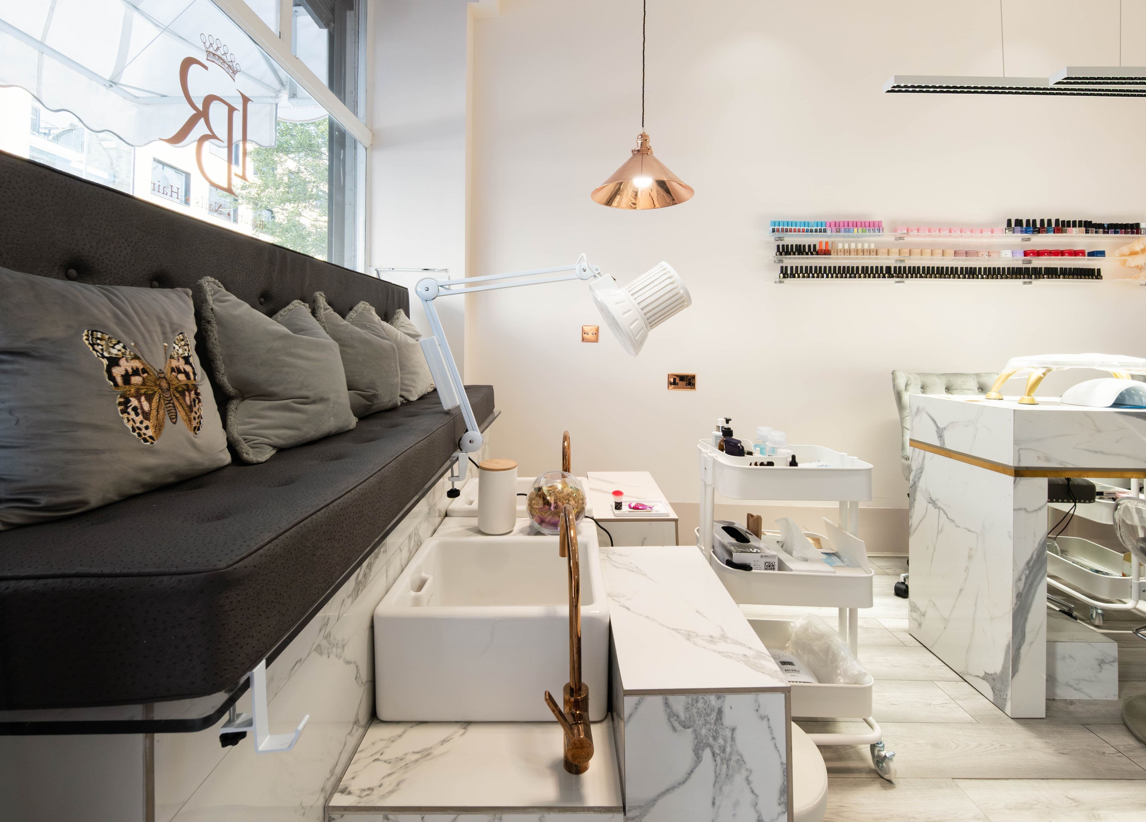 Elegant interior of NOGTI Nails Fitzrovia in London, England, GB with plush seating and manicure stations.