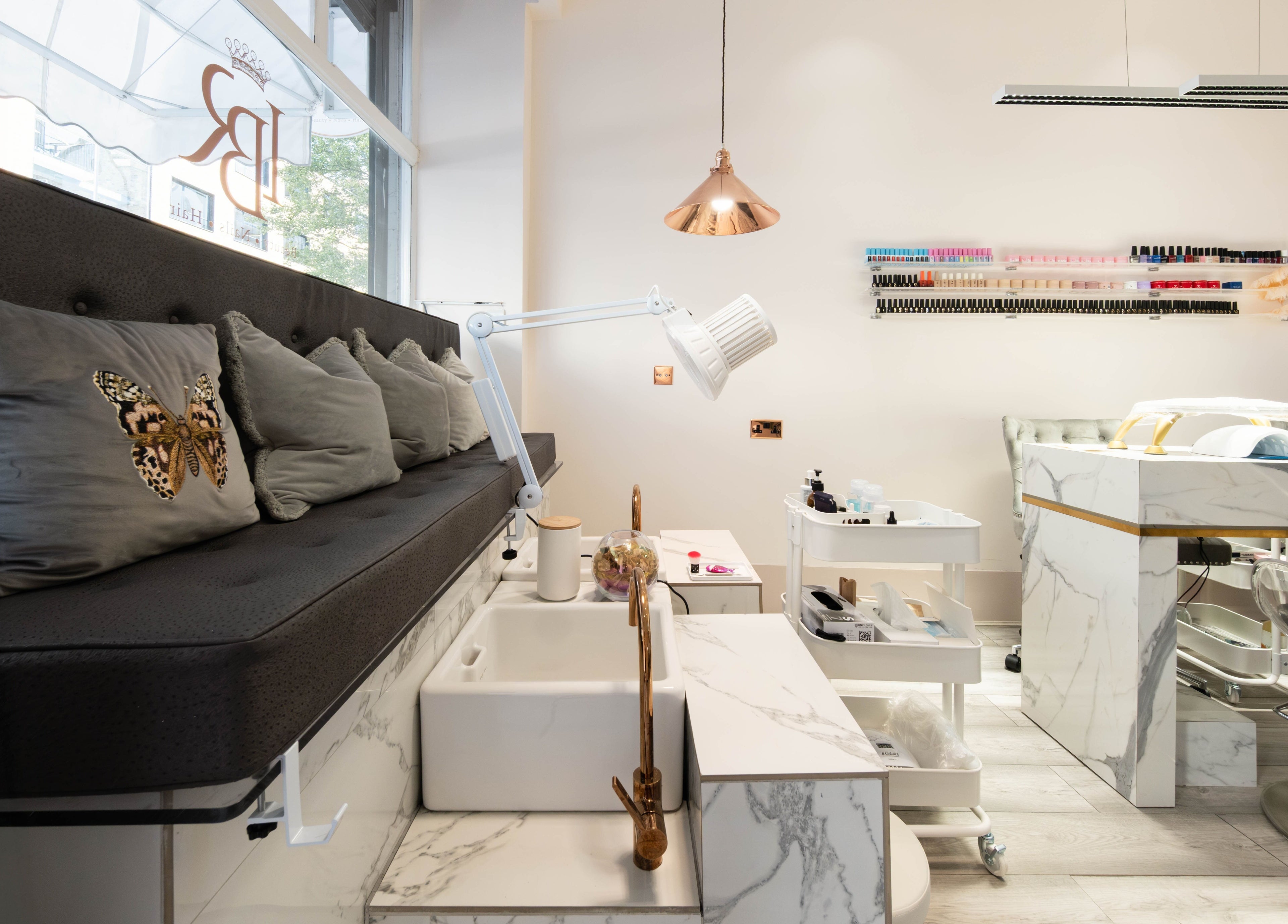 Elegant interior of NOGTI Nails Fitzrovia in London, England, GB with plush seating and manicure stations.