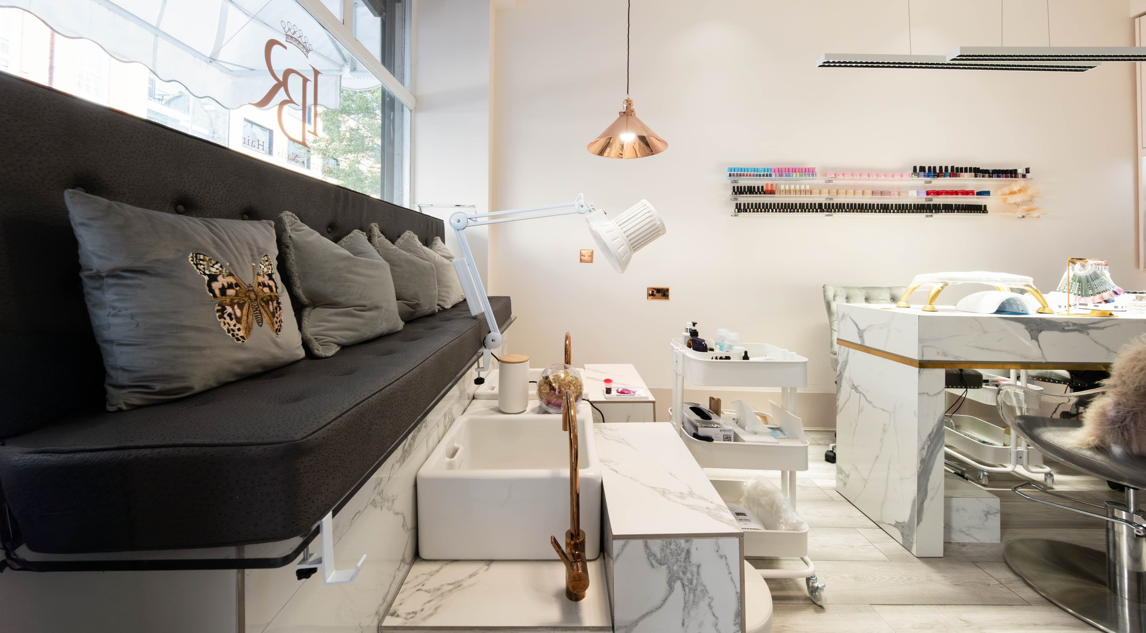 Elegant interior of NOGTI Nails Fitzrovia in London, England, GB with plush seating and manicure stations.