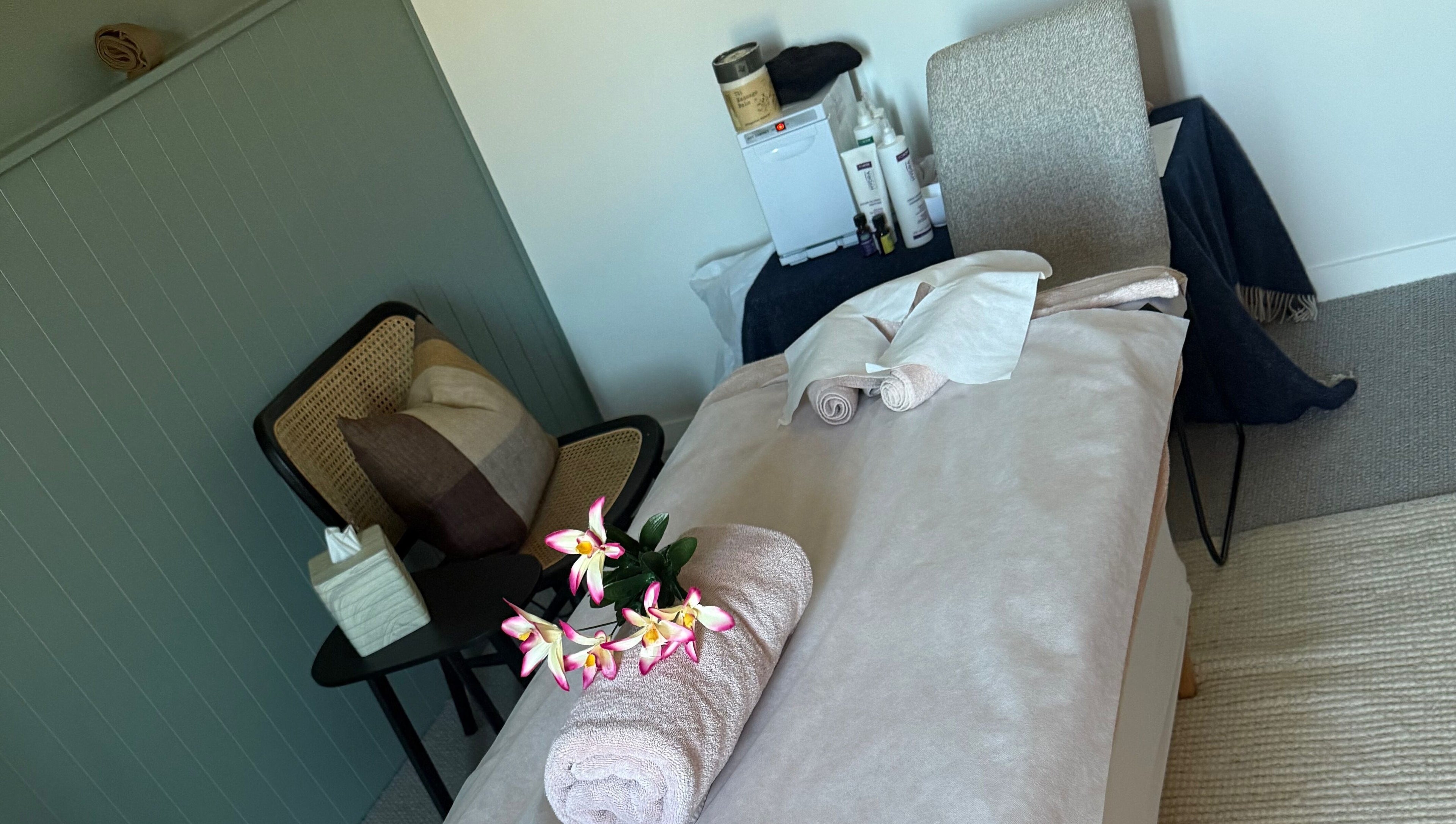 Sophie Spa treatment room with orchid and towel in Auckland, NZ, offering a calm and relaxing atmosphere.