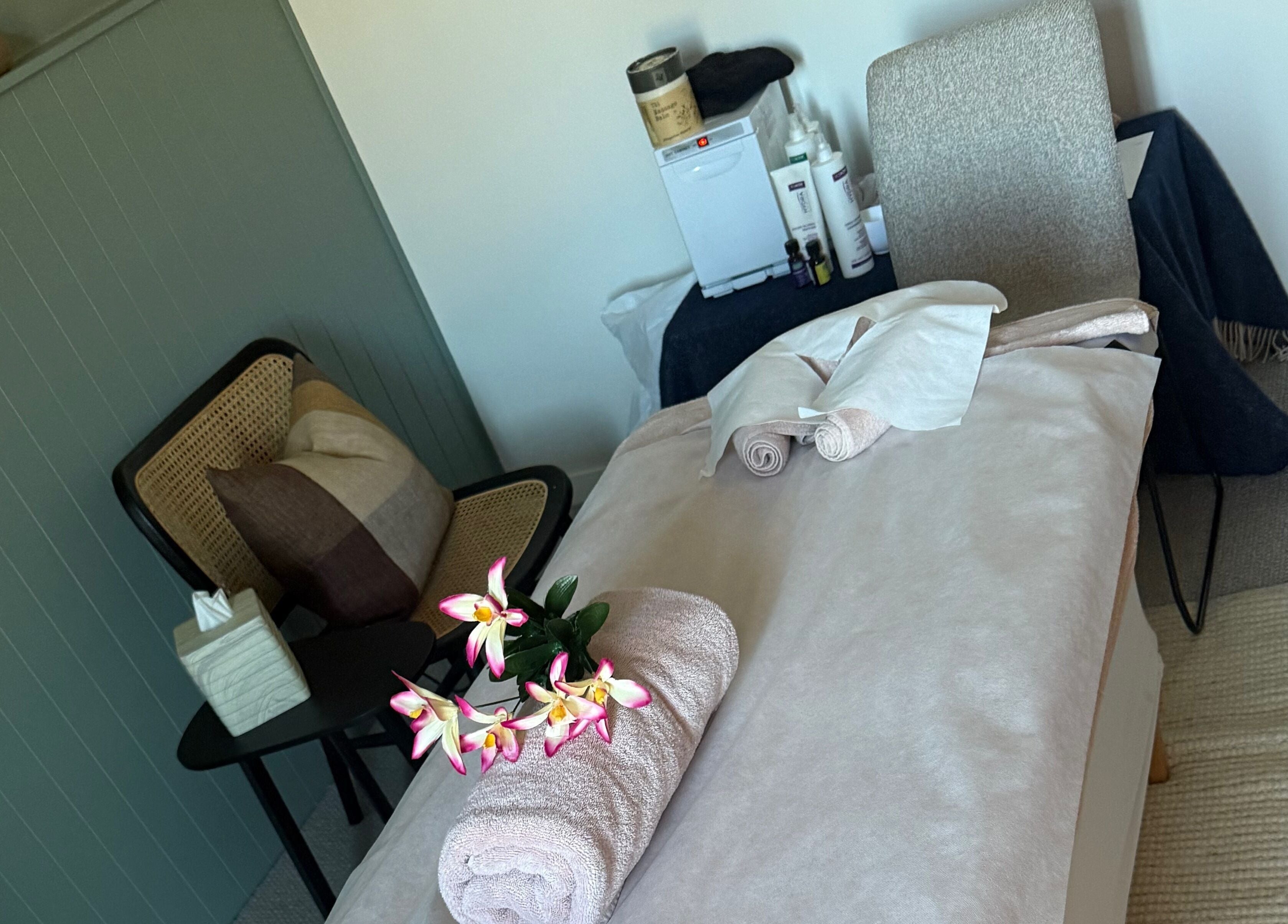 Sophie Spa treatment room with orchid and towel in Auckland, NZ, offering a calm and relaxing atmosphere.