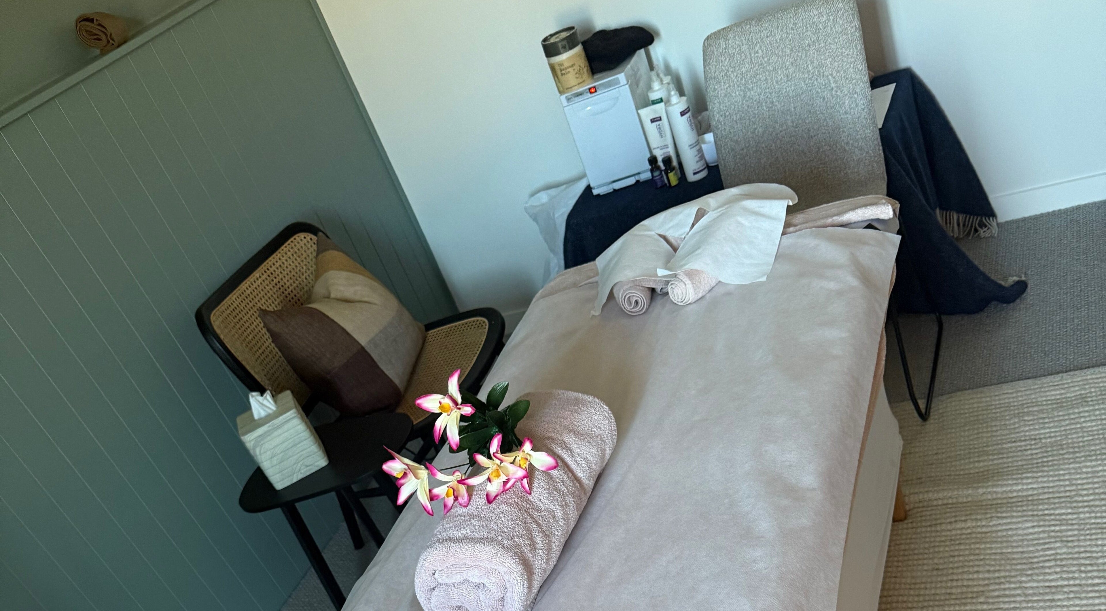 Sophie Spa treatment room with orchid and towel in Auckland, NZ, offering a calm and relaxing atmosphere.