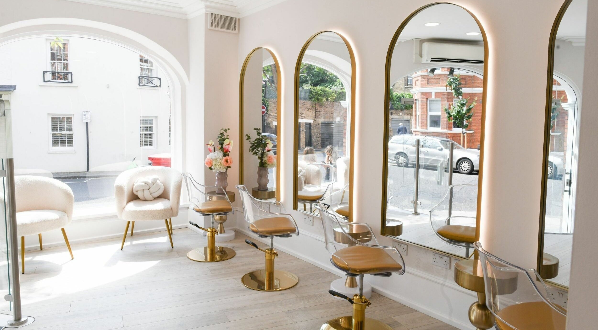 Chic interior of Sisters Salon Hair in London, England, GB with elegant chairs facing large mirrors.
