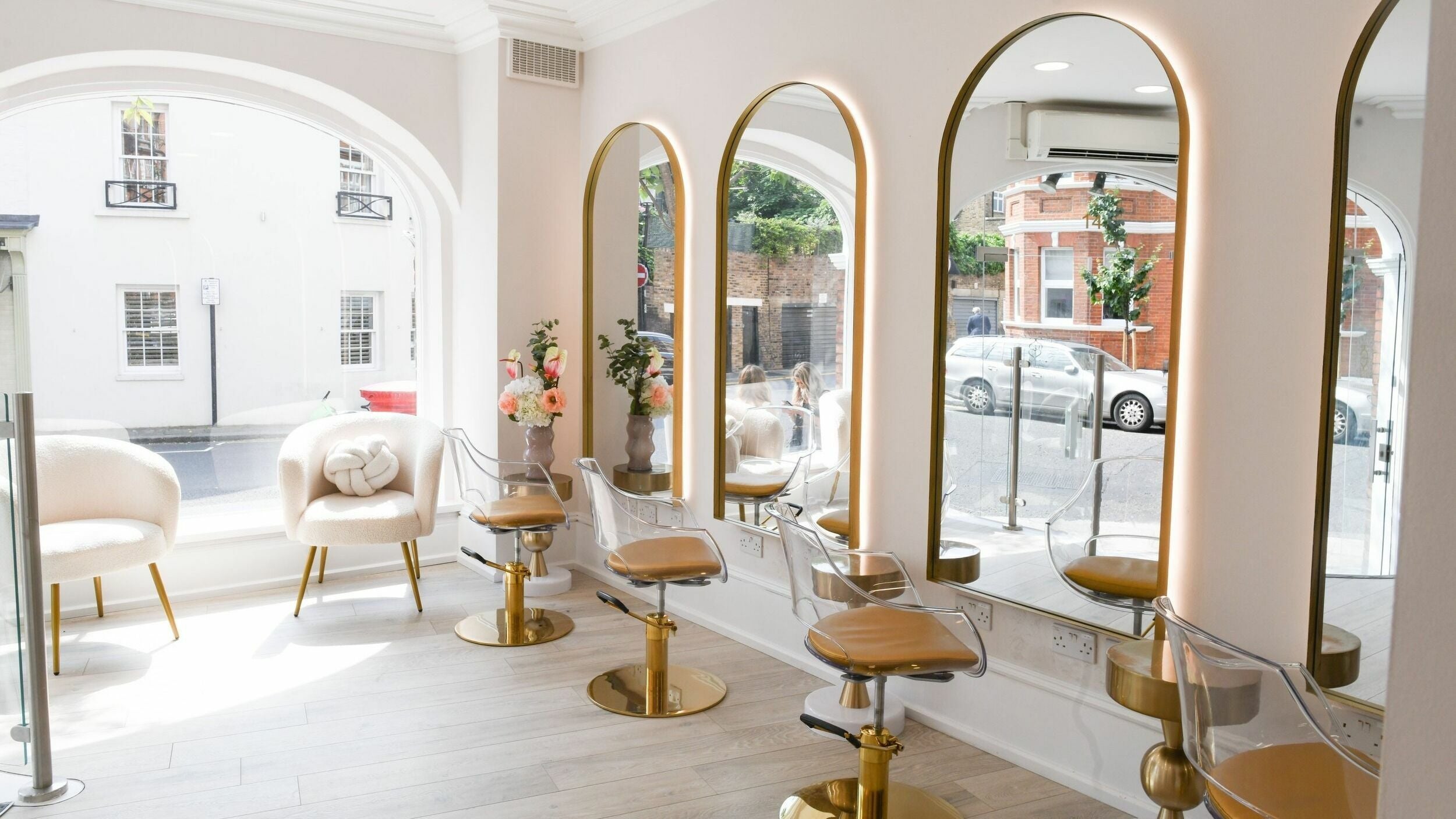 Chic interior of Sisters Salon Hair in London, England, GB with elegant chairs facing large mirrors.