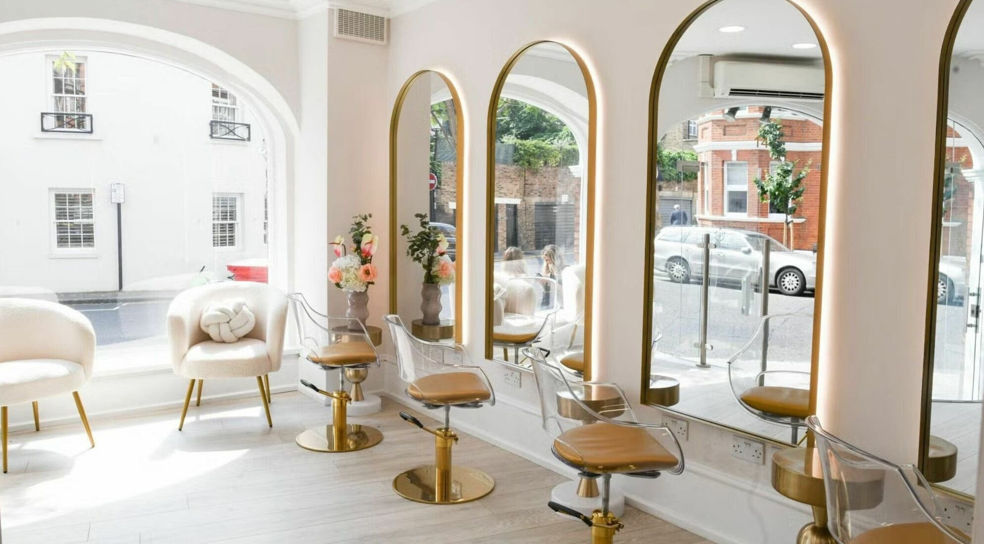 Interior of Sisters Salon Beauty in London, England, GB with elegant mirrors and gold-accented chairs.