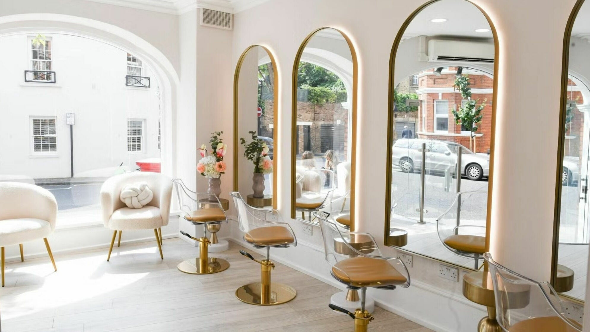 Interior of Sisters Salon Beauty in London, England, GB with elegant mirrors and gold-accented chairs.
