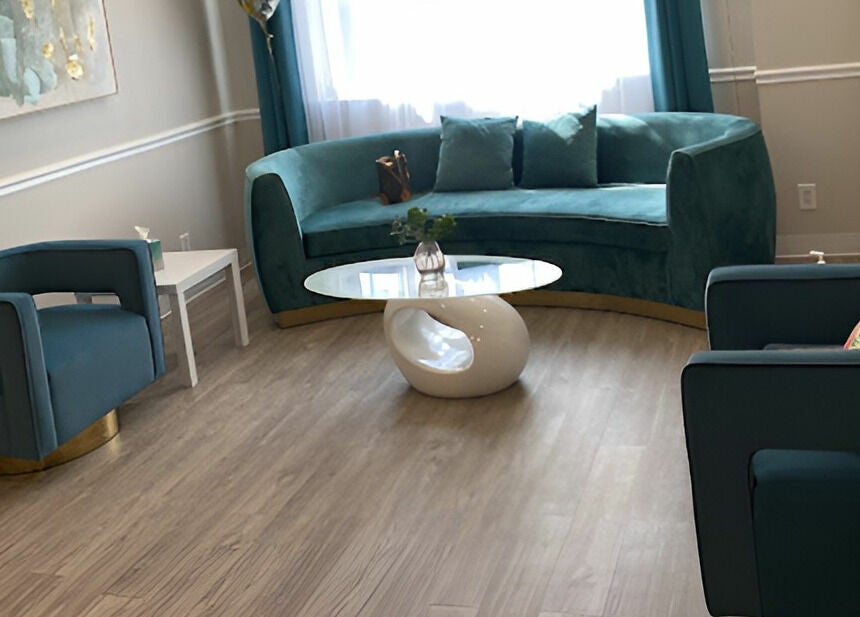 Elegant lounge area with teal sofa at Unique Massage Spa in Fairfax, Virginia, US.