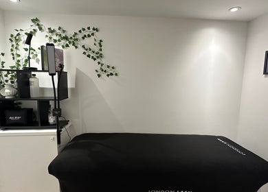 Relaxing treatment room at Cured by Beth, Edinburgh, Scotland, GB with calming decor and cozy massage bed.