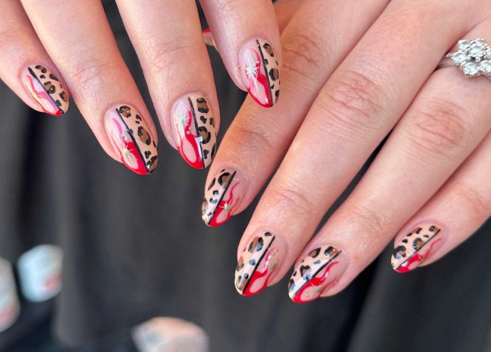 Stylish leopard print nails with red accents at Cured by Beth, Edinburgh, Scotland, GB.