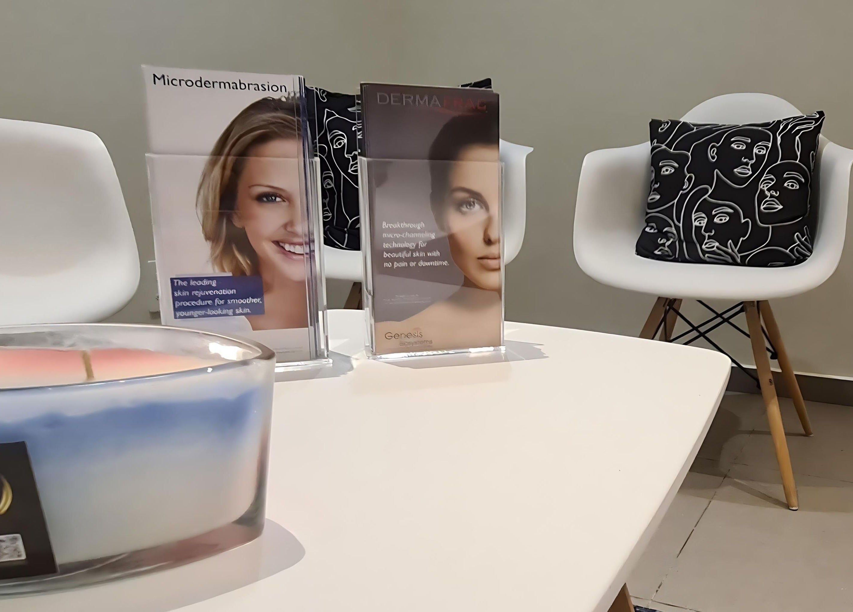 Cozy seating area at Elite Laser Aesthetics, Randburg, Gauteng, ZA with stylish chairs, brochures, and a candle.