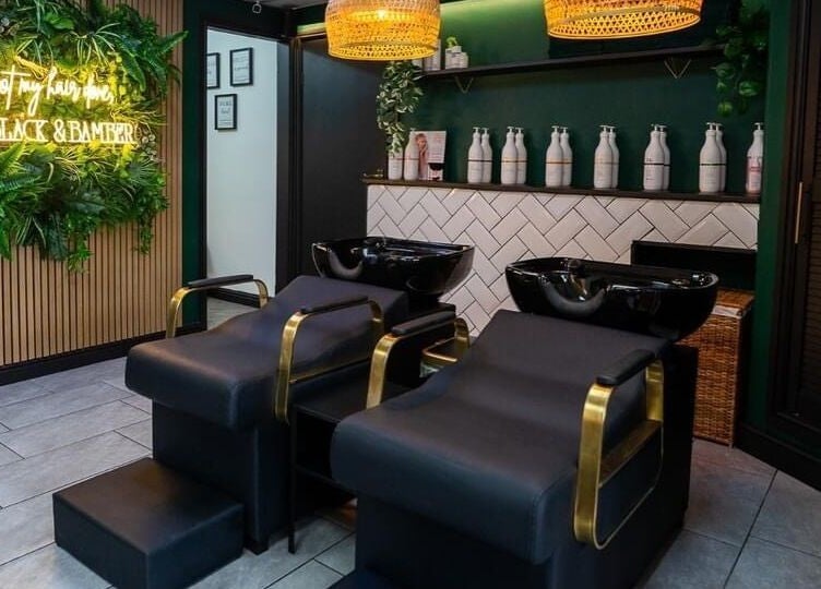 Elegant salon setup at Black & Bamber, Hull, England, GB, featuring stylish black wash stations and lush greenery.