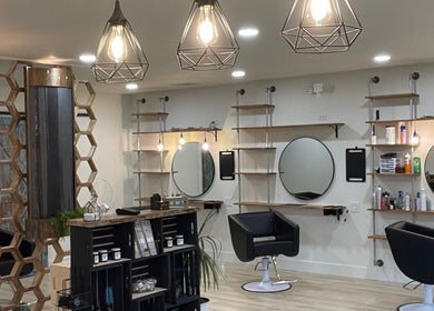 Modern interior of The Copper Moss salon in Haysville, Kansas, US, featuring stylish chairs and geometric lights.