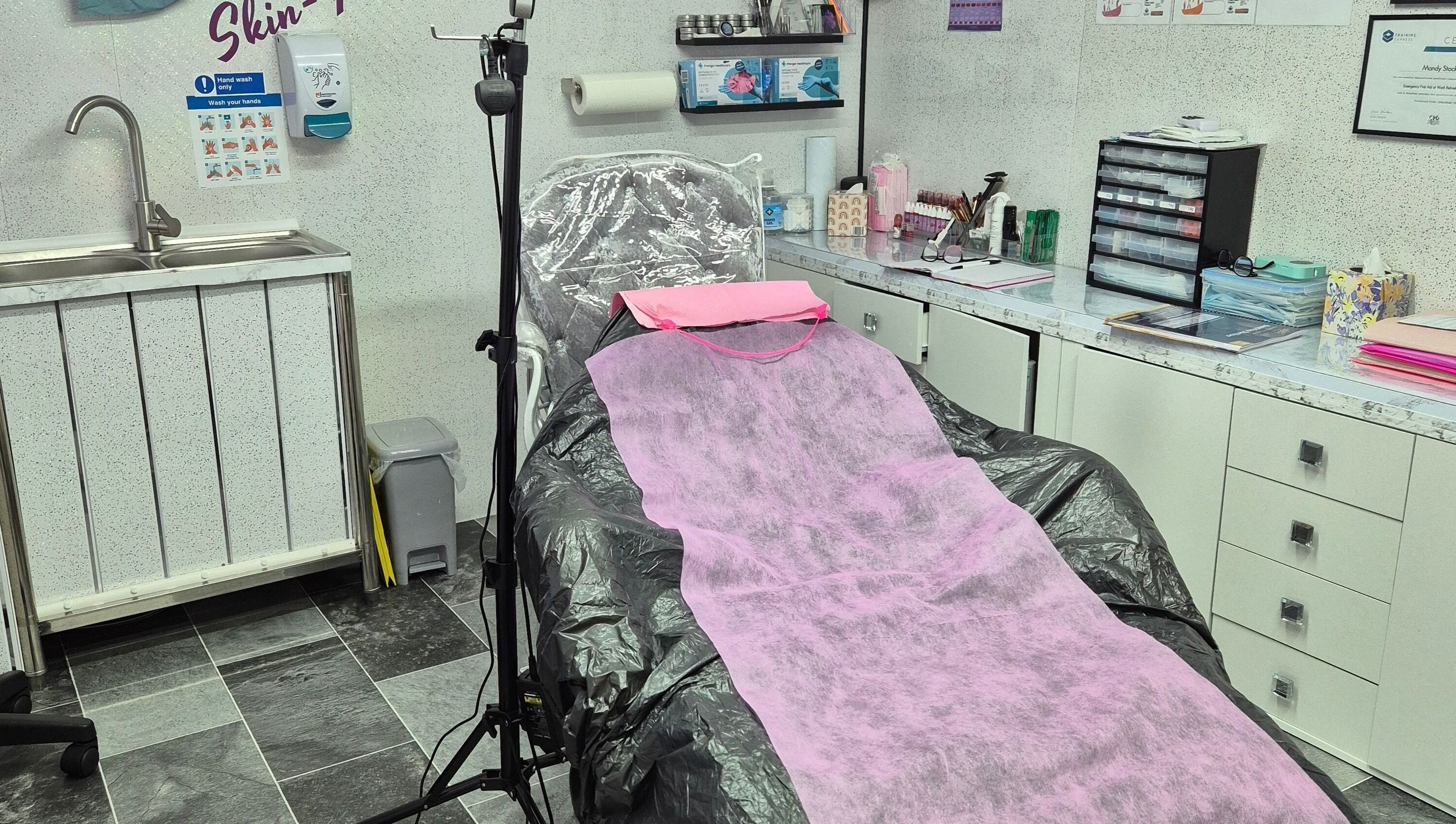Skin-Finity treatment room with pink draped chair in Aylesham, England, GB, showcasing a clean, professional setup.