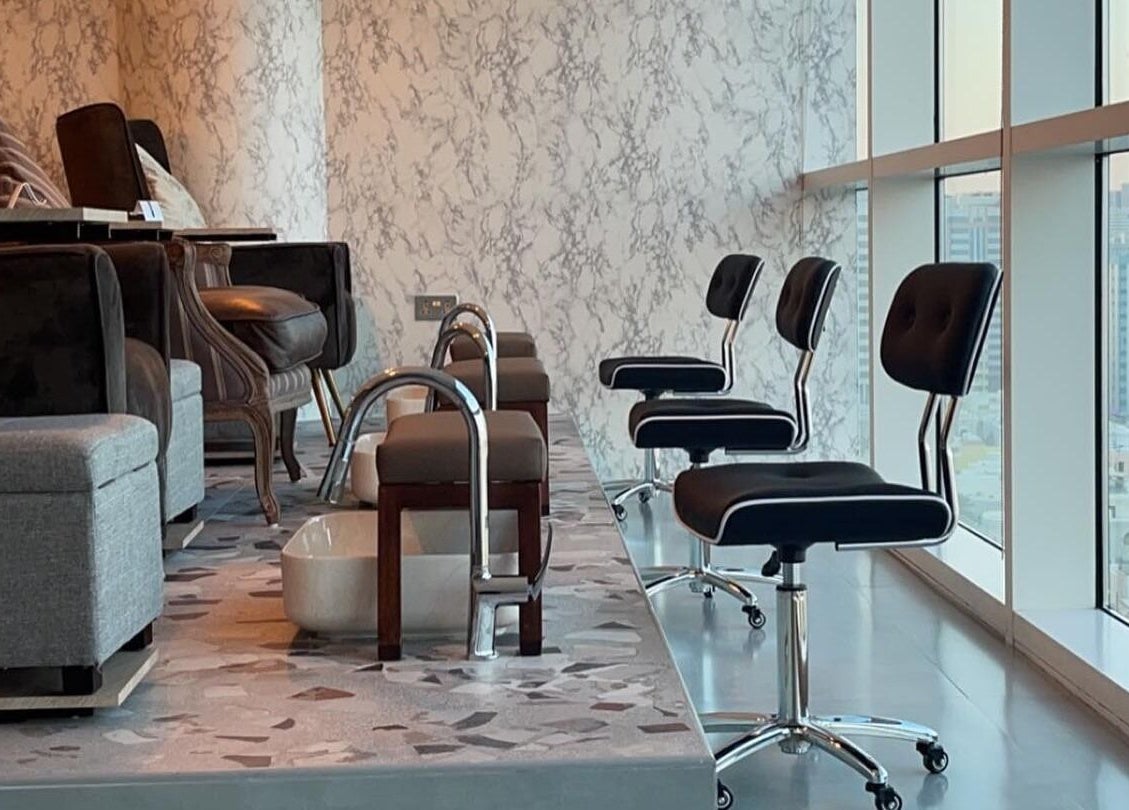 Luxurious pedicure station at Bel Fiore Ladies Salon, Abu Dhabi, featuring modern chairs and city views.