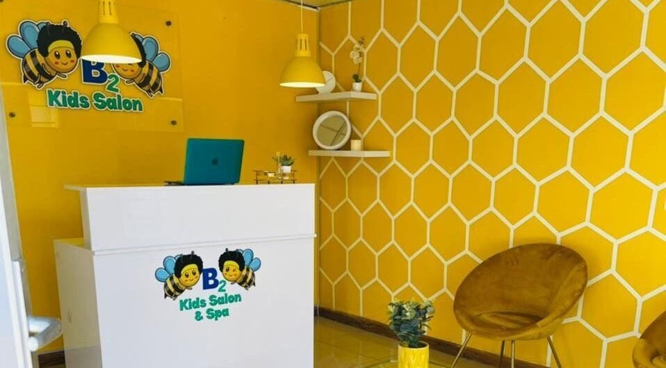 Reception area of Bee2 Kids Salon in Kempton Park, Gauteng, ZA with a vibrant yellow honeycomb wall.