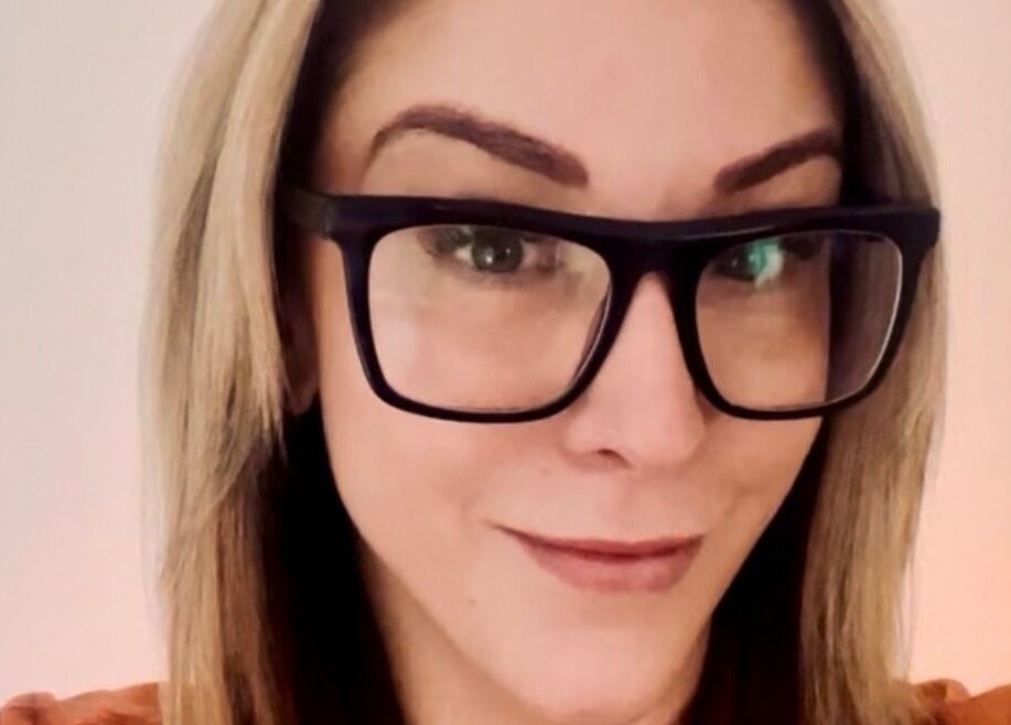 Smiling woman with glasses at Tres Beaux Aesthetics in Birmingham, England, GB.