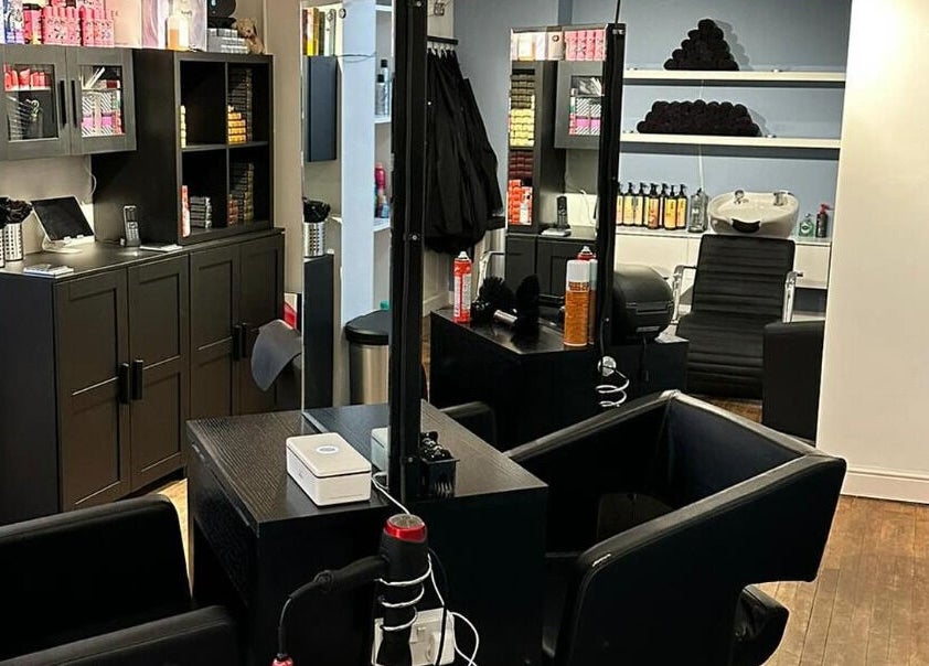Modern salon interior at Whites Hairdressing, Bromyard, England, GB featuring sleek design and styling stations.