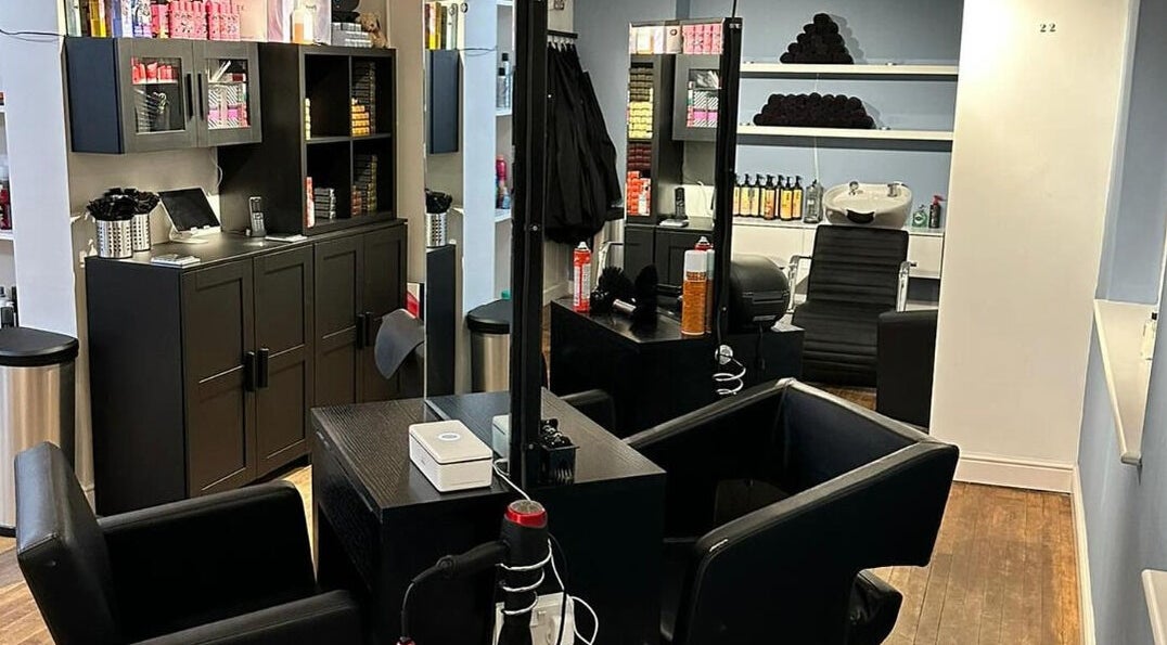 Modern salon interior at Whites Hairdressing, Bromyard, England, GB featuring sleek design and styling stations.