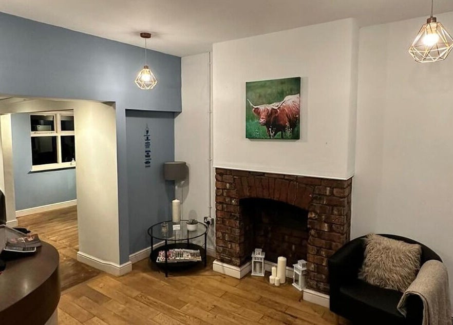 Cozy interior at Whites Hairdressing, Bromyard, England, GB, featuring a modern fireplace and seating area.