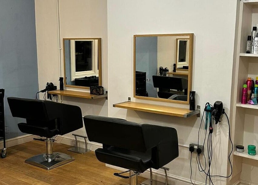 Modern salon chairs and mirrors at Whites Hairdressing in Bromyard, England, GB.